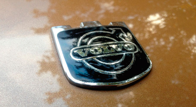 Man ser volvo logo på en bil.