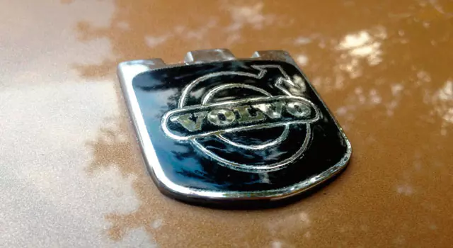Man ser volvo logo på en bil.