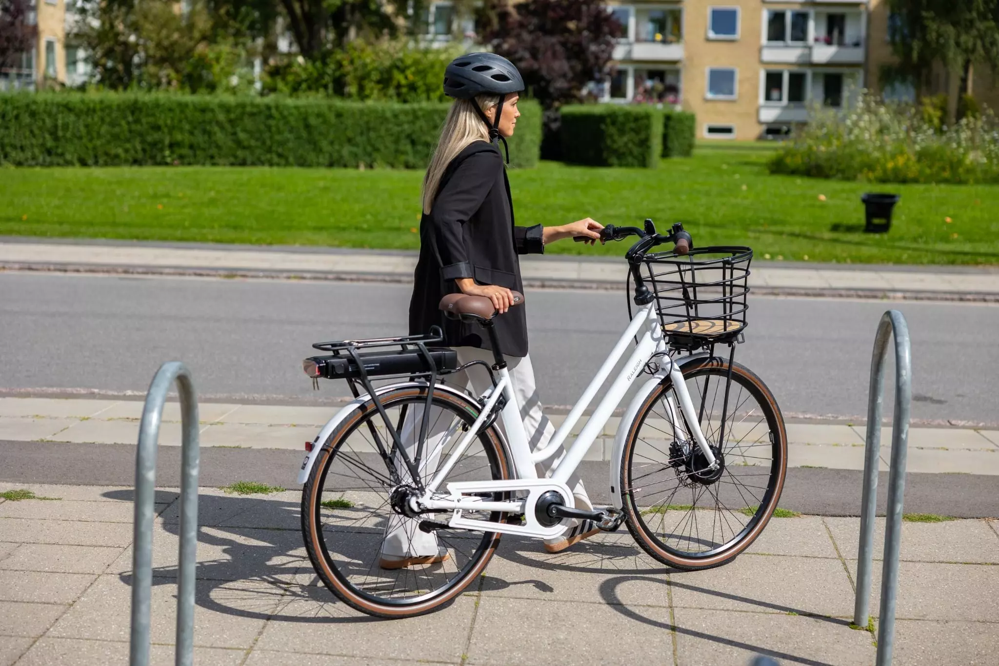 En kvinde går med sin cykel.