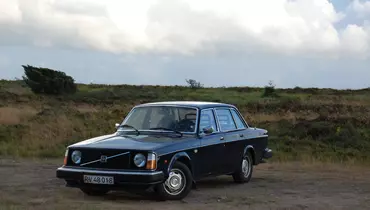 Billedet viser en volvo der holder parkeret i et skovområde.