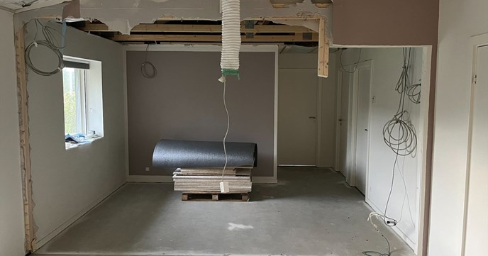 Interiør under ombygning med materialer og åben væg, der illustrerer behovet for en ombygningsforsikring.