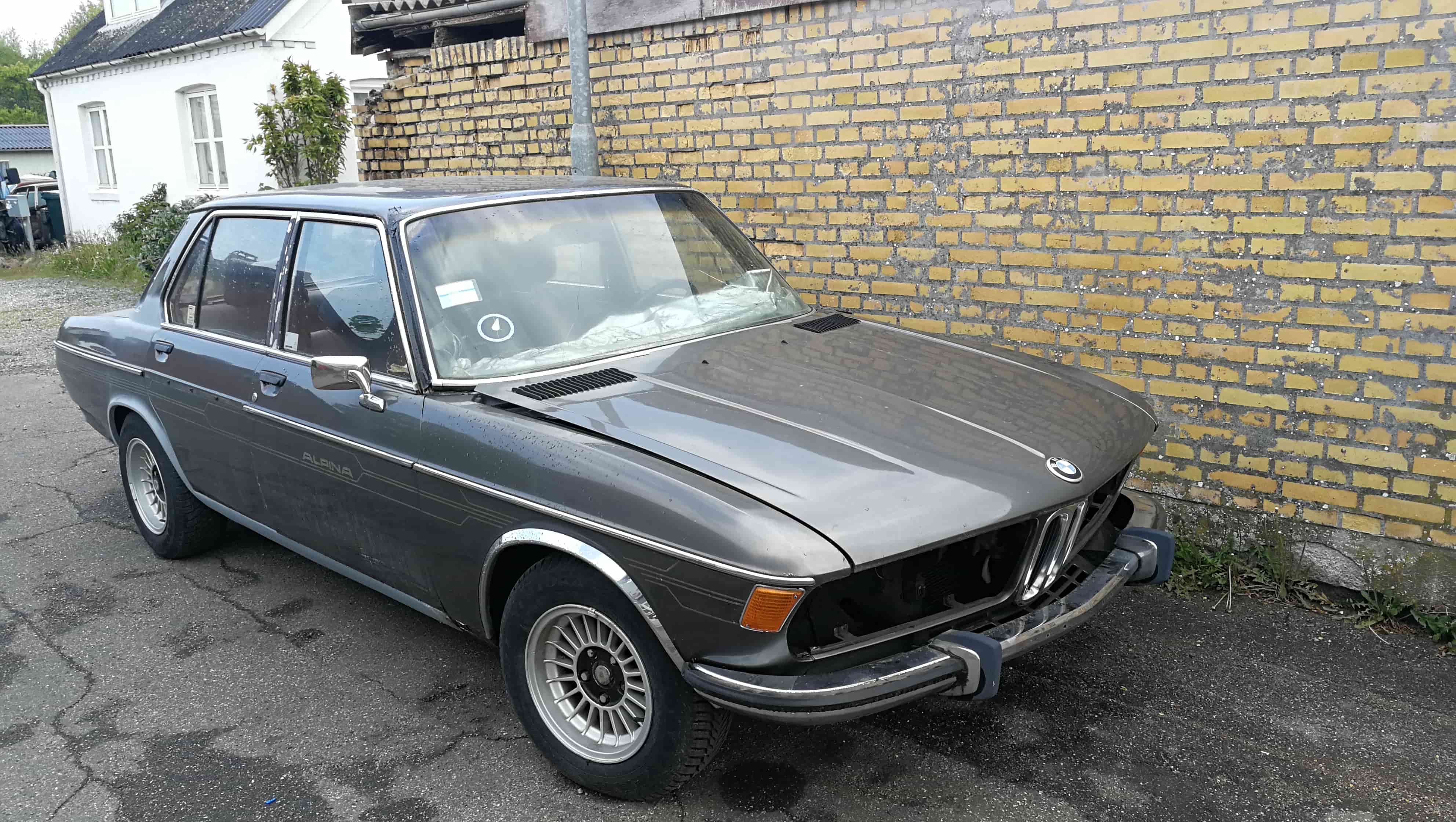 En klassisk bil der holder parkeret foran en bygning.