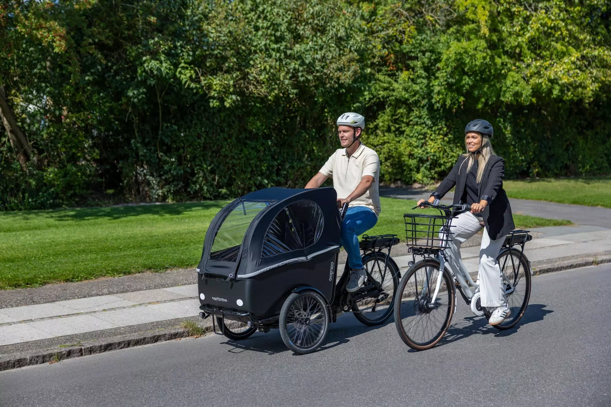 En mand og en kvinde kommer cyklende på en vej.