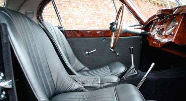 Billedet viser en bil indefra. Bilen er med lædersæder og af ældre dato.