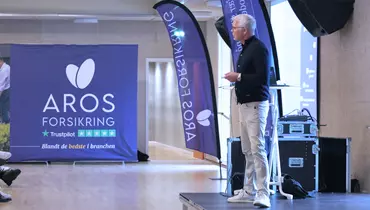 Nytårsbriefing i Aros Forsikring. Direktor Morten Dissing står på scenen.