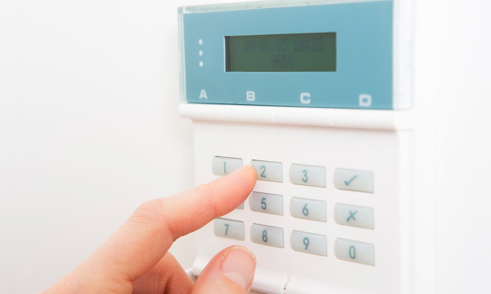 En alarm med en finger der trykker på tasterne.