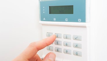 En alarm med en finger der trykker på tasterne.