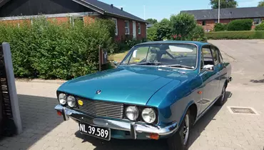 En klassisk bil holder parkeret i et boligområde.