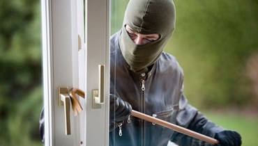 En tyv med elefanthue der er på vej til at brække en dør op.