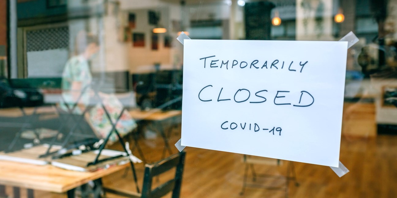 A sign saying Temporarily Closed sign on a cafe door