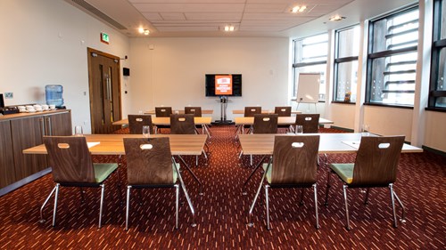 Aylesbury Theatre meeting room set up in classroom format with plasma screen at the front and desks and chairs behind