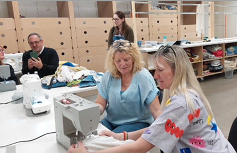 (Tracy Edwards, Re-Fashion Volunteer, teaching Shona Jeffries, Retail Volunteering Team, how to sew. Shona made a pair of shorts from some joggers).