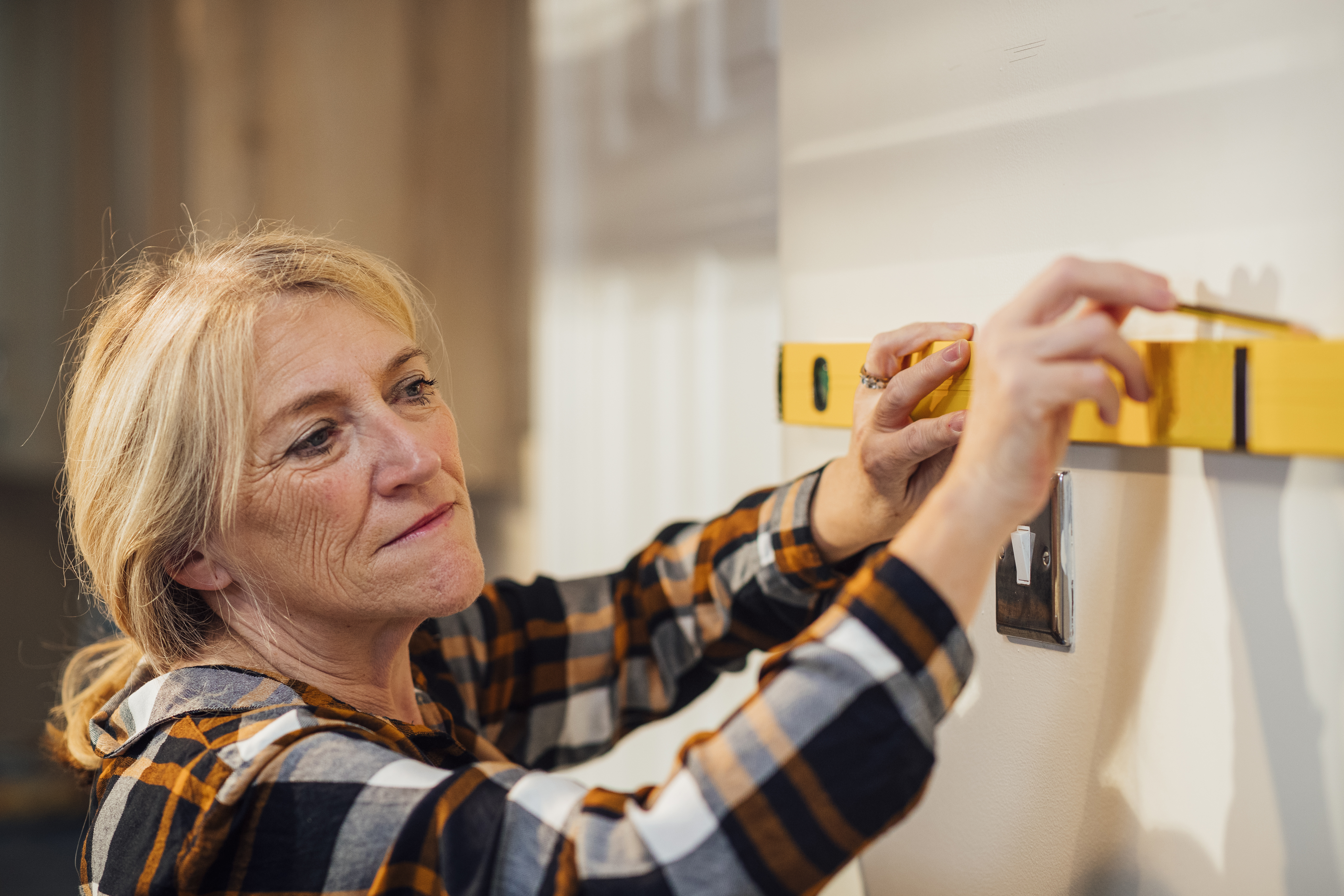 Lady doing DIY, using spirit level
