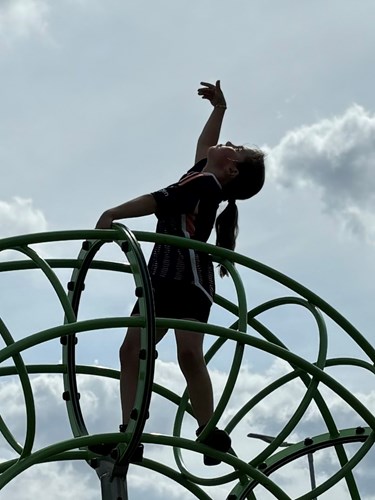 Child on play area hands in air