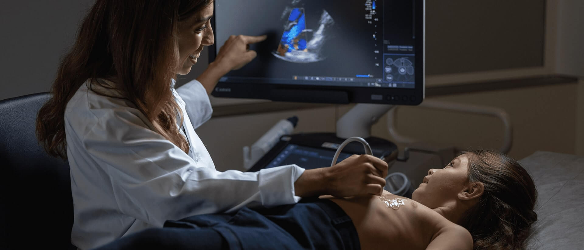 Pediatrician performing an echocardiogram on a patient
