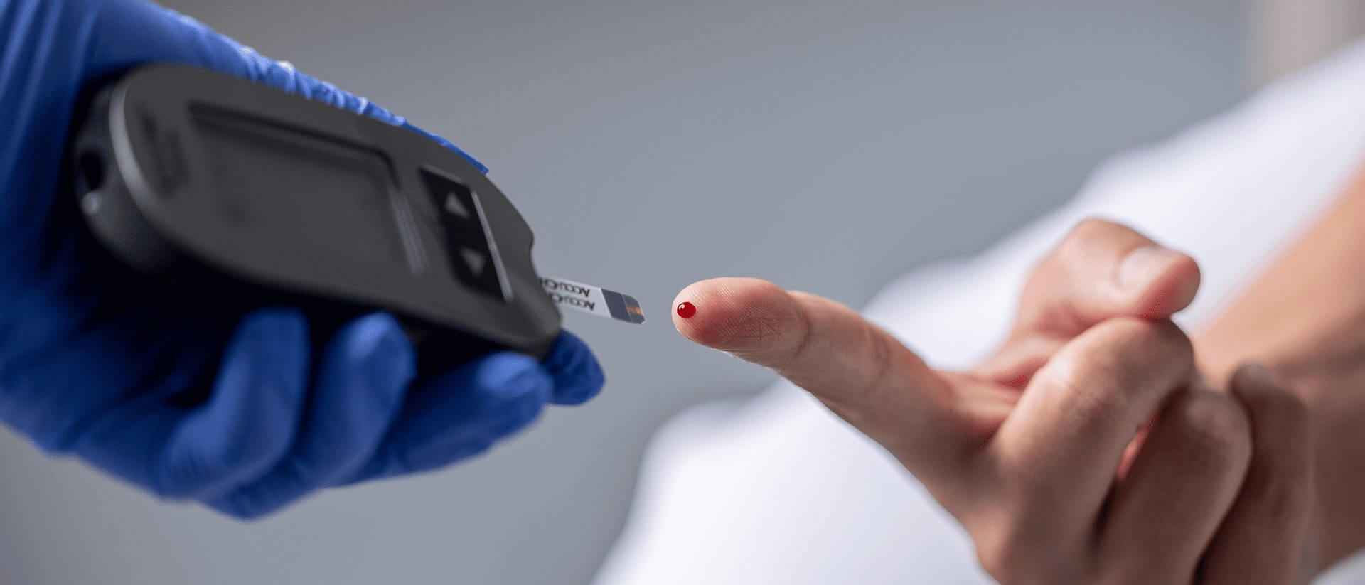 Testing a drop of blood on the patient's fingertip