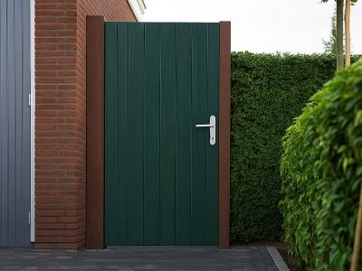 Groene buitendeur in de schutting