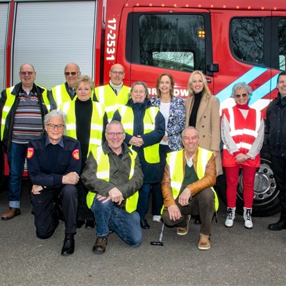 Huurders van Woonzorg na brandveiligheid training bij brandweerauto