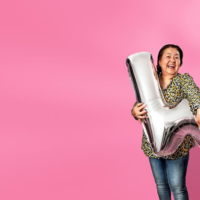 Vrouw met donker haar houdt zilveren ballon in W-vorm vast