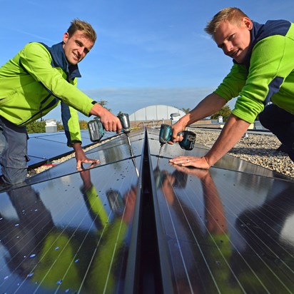2 installatiemonteurs monteren zonnepanelen op dak