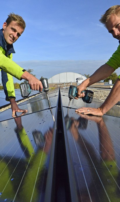 2 installatiemonteurs monteren zonnepanelen op dak