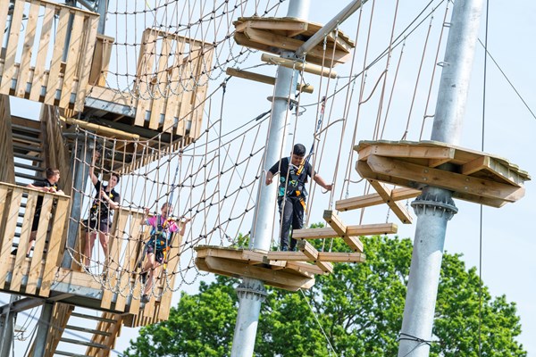 Visitors walking on an outdoor course with netting high up at Adventures at Kings Mill Reservoir