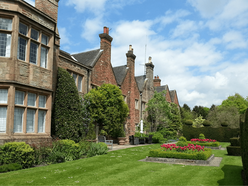 The building of Felley Priory house with its garden containing flowers