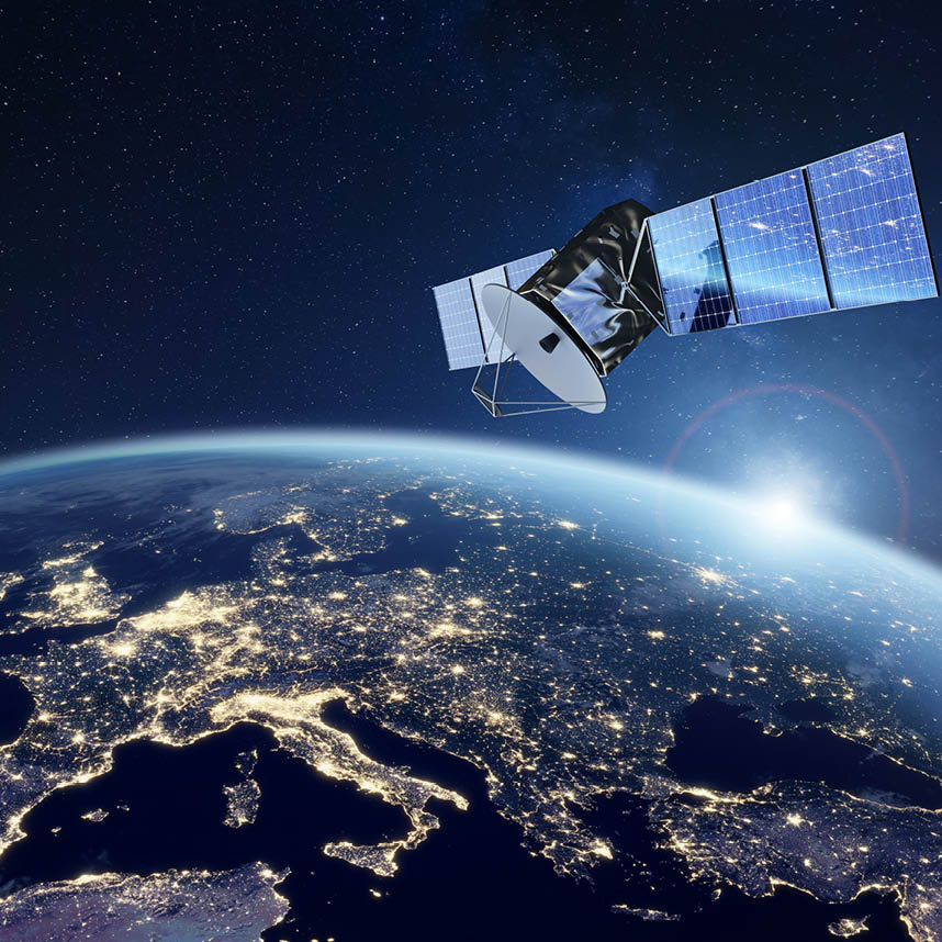 Satellite orbiting above Earth with illuminated continents at night.