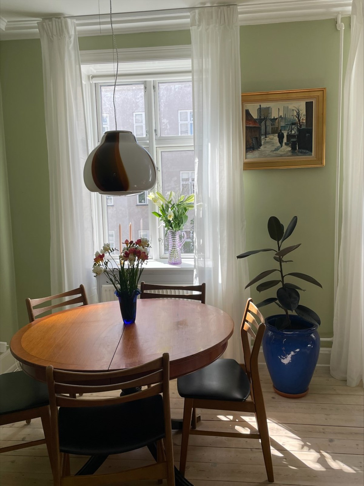 Laura elsker parrets spisebord, spisebordsstole og den smukke Murano-lampe. Hun er også særligt glad for den store, blå gulvkrukke, som hun har købt på DBA for 800 kroner. Billedet over den blå krukke har August arvet fra sin elskede morfar.