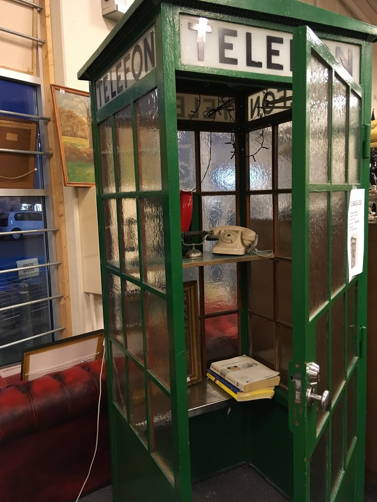Telefonboksen er fra 1930’erne og har engang huseret på gaden ligesom andre telefonbokse. Den vejer cirka 450 kilo og har også en dør i sig, så det er muligt at lukke boksen og derved kunne tale uforstyrret. Der hører ingen telefon med til telefonboksen. Telefonboksen kan låses udefra
