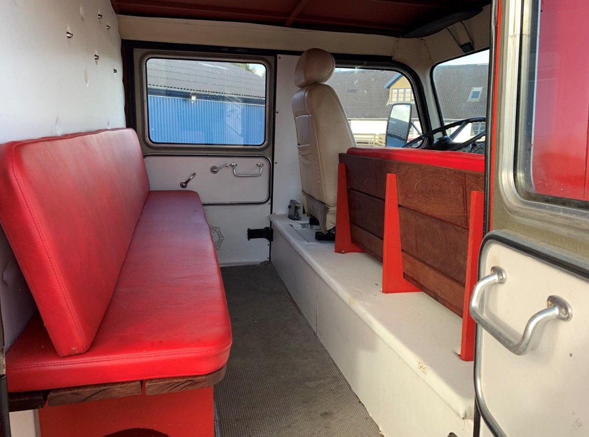 Der er god plads i kabinen og røde lædersæder. Den er registret som bus til 9 personer, og kan registreres som veteranbil