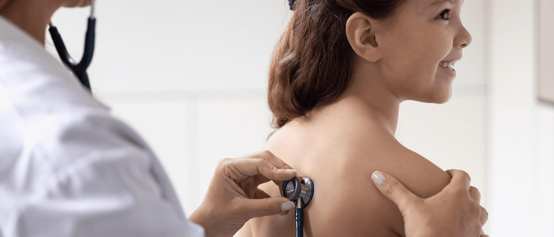 Doctor placing a stethoscope against a patient's back 