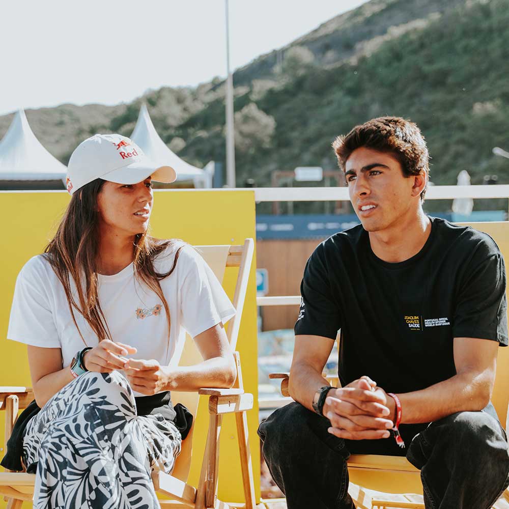 Surfers Teresa Bonvalot and Joaquim Chaves sitting and chatting