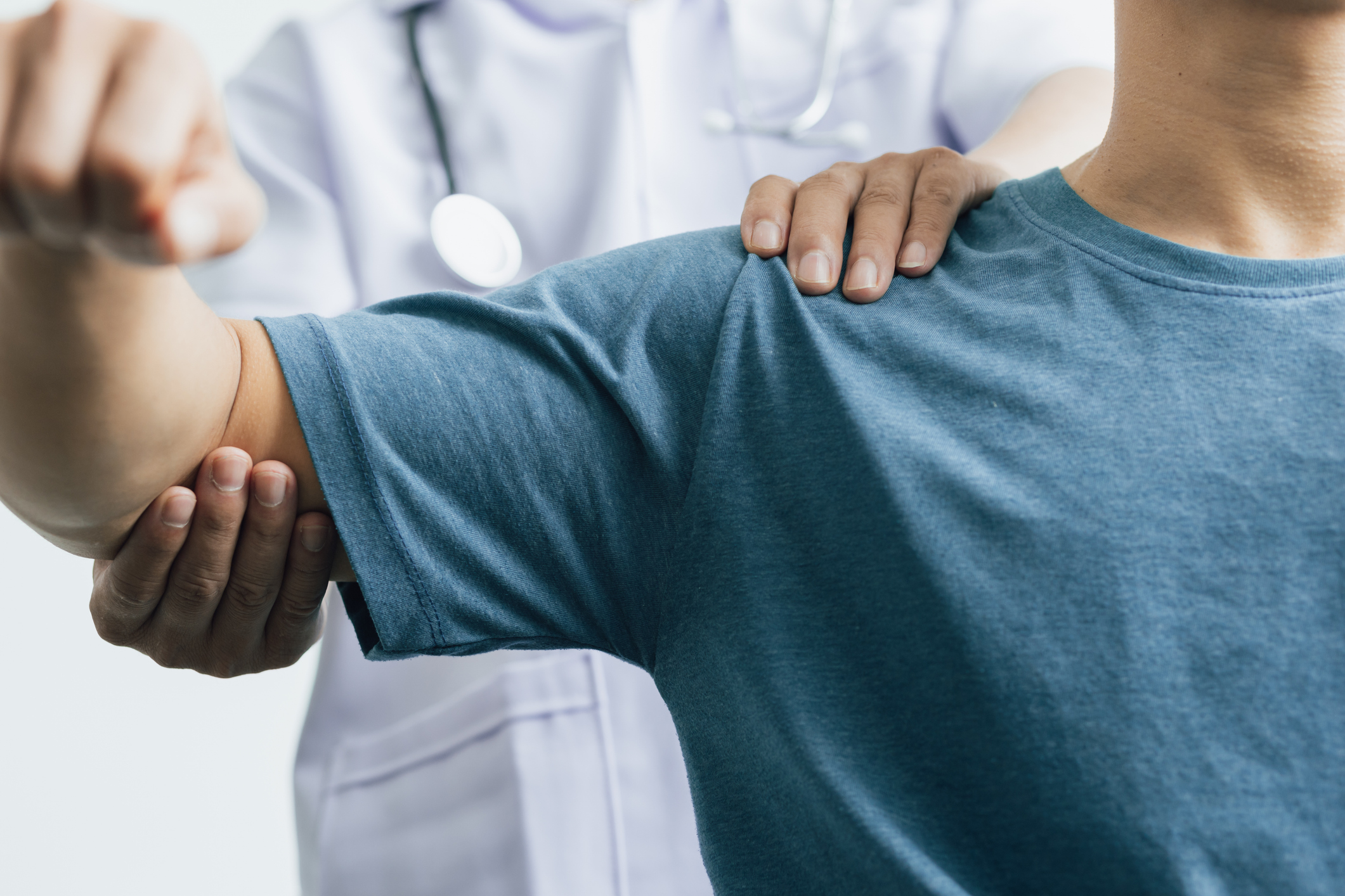 Orthopedic doctor examining a patient's arm during a consultation