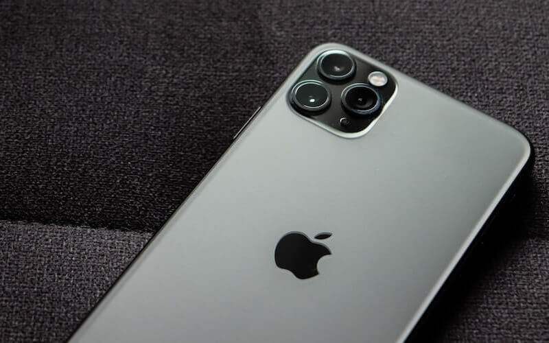 A grey iPhone Pro model with camera and back of device facing upwards