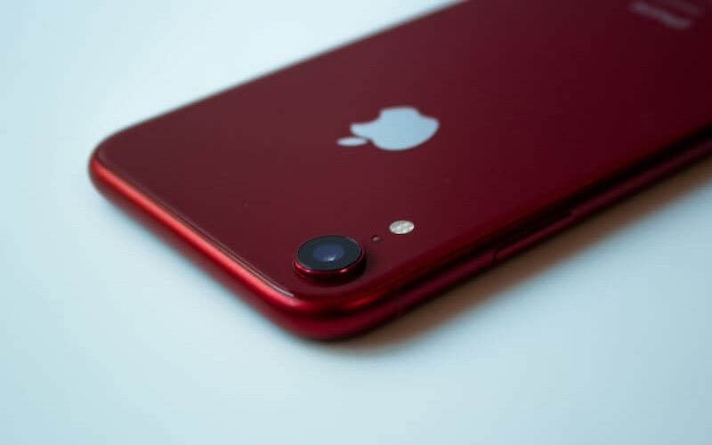 A red iPhone model lay on a table