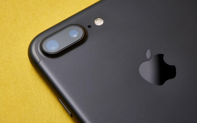 Close up of the camera bump on a black iPhone model, lay on a yellow table