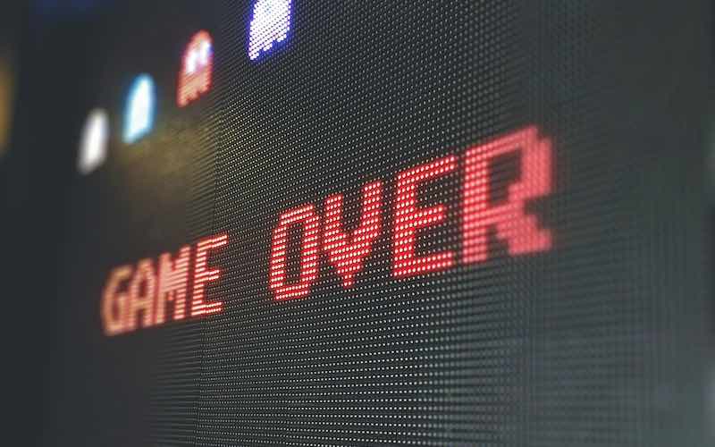 A black screen showing the words 'Game Over' in red lettering, with the colourful ghosts from Pac Man framing the top of the screen.