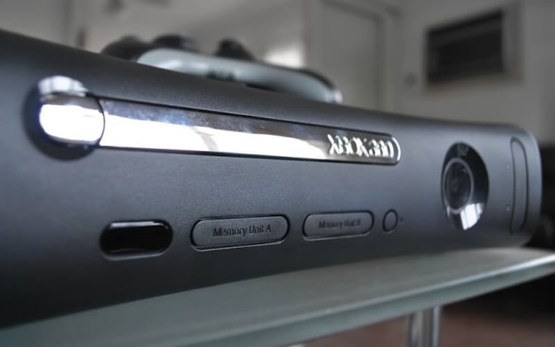 A black Xbox 360 console with a chrome disc tray