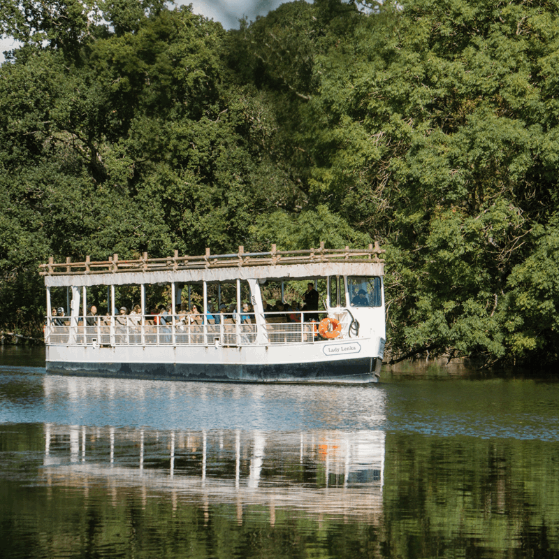 A boat on a calm lake with trees in the background