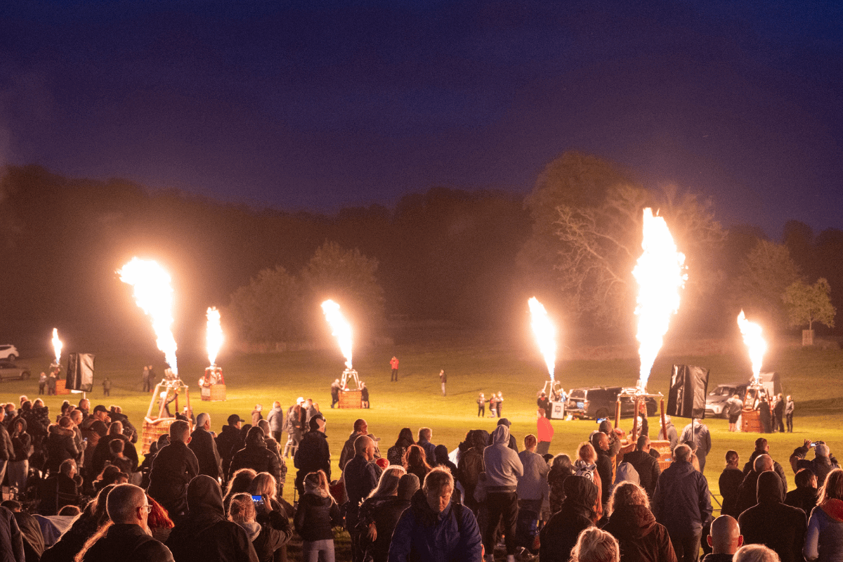 crowd watching balloon basket glowing