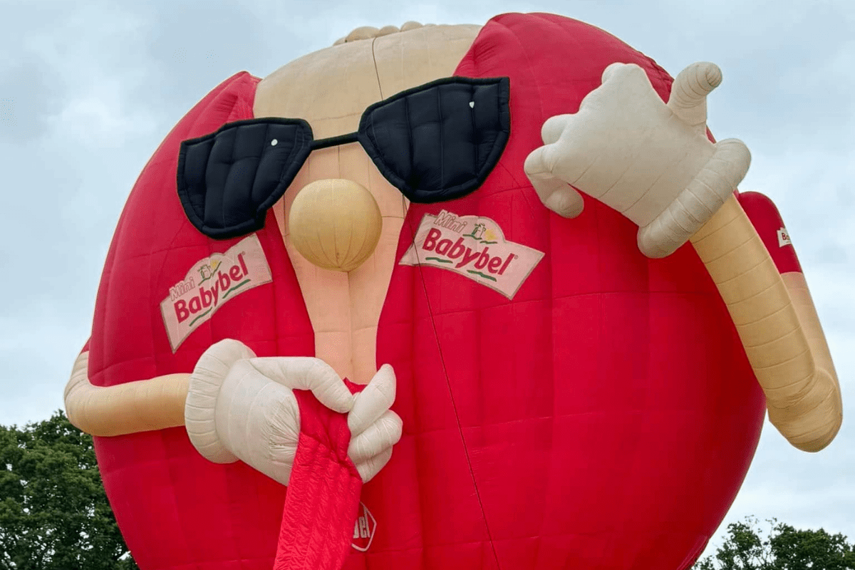 A balloon shaped as a babybel with sunglasses on