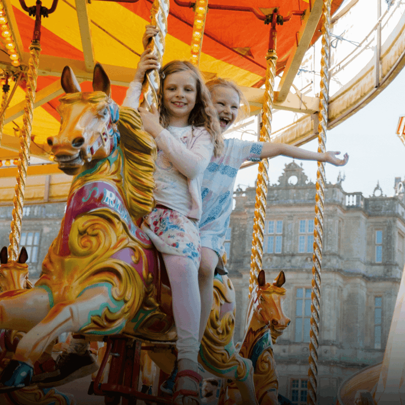 Two girls on a carousel horse outside Longleat House