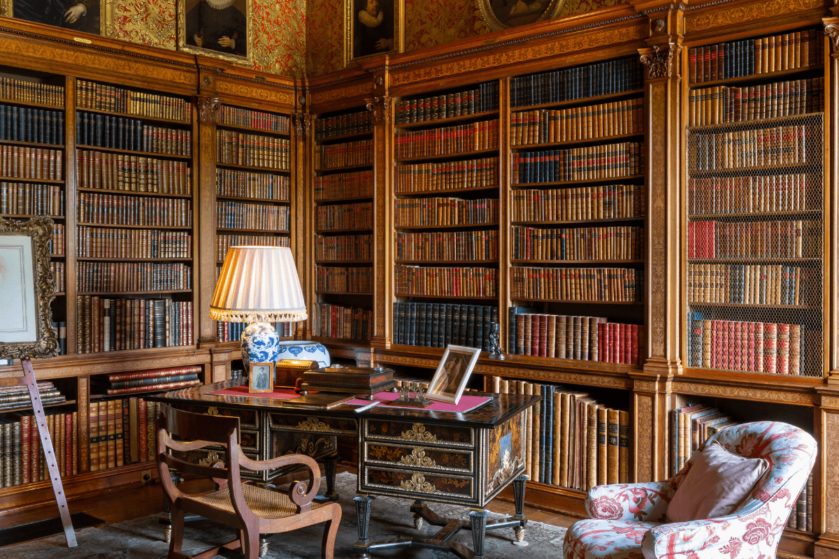 A wide shot of one of the Longleat libraries, with books, art and furniture on display