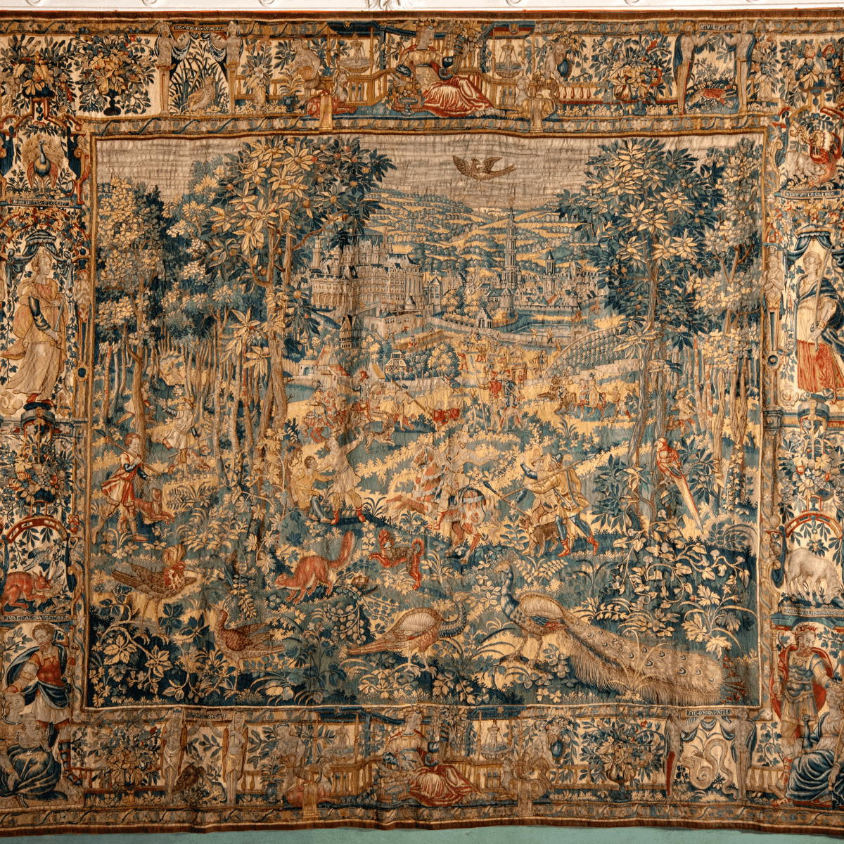 A tapestry featuring an array of people, animals, trees and plants