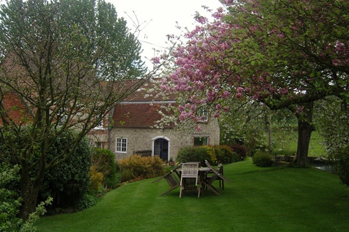 Mill Farm B&B - A stone building with a lawned garden and trees in bloom.