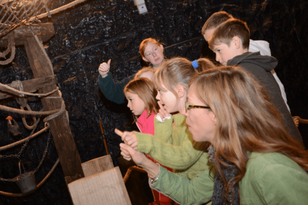 Children in bat cave with keeper