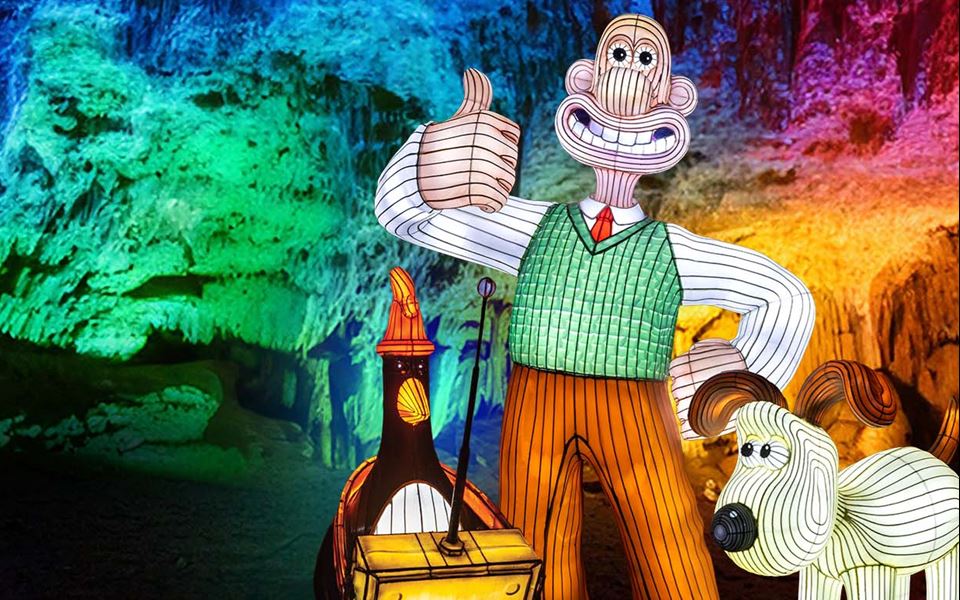 A promotional poster for the illuminated cave at Cheddar with Wallace & Gromit in lantern form