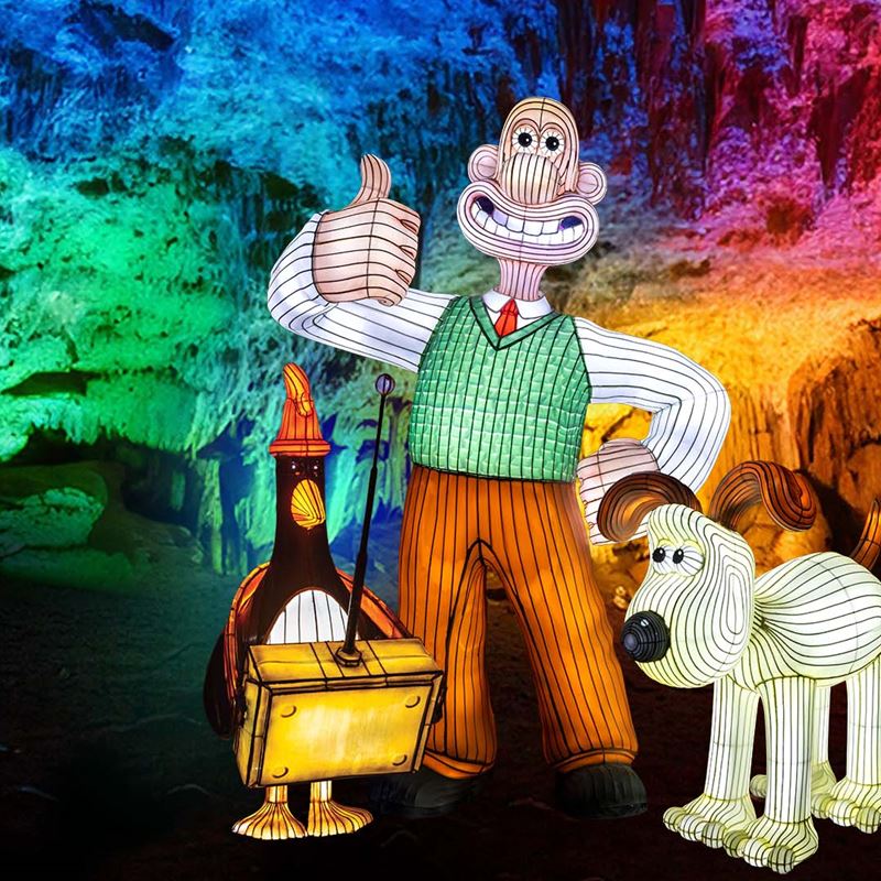 A promotional poster for the illuminated cave at Cheddar with Wallace & Gromit in lantern form
