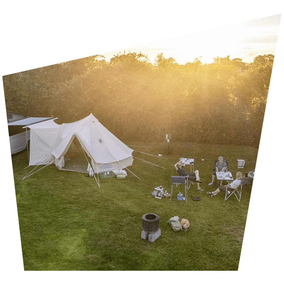 A group of campers sit beside their tent set-up at Greenacres Camping